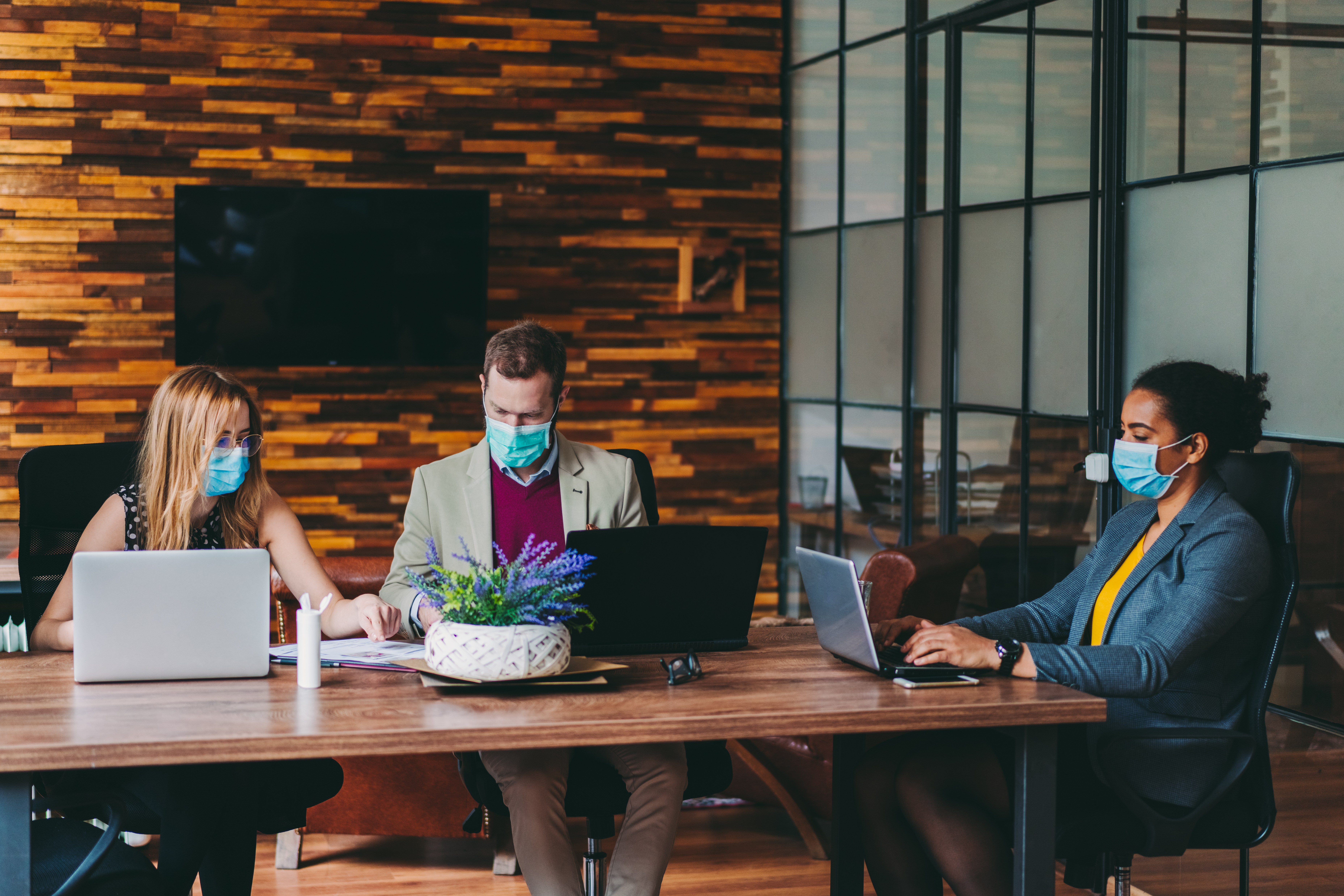 Business group at table with masks