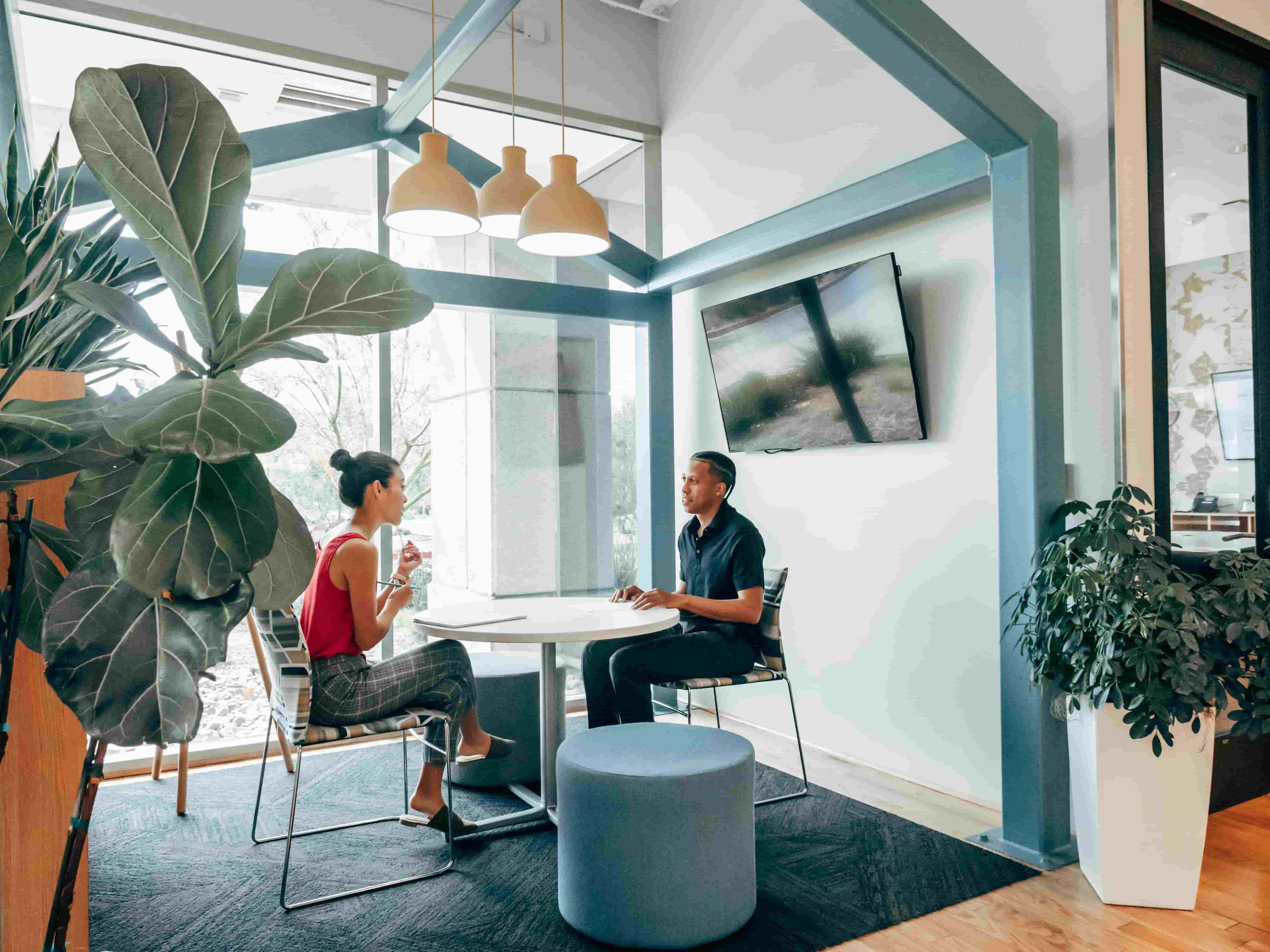 Two event planners sat in a meeting room surrounded by plants | Global Agency. BCD Meetings & Events