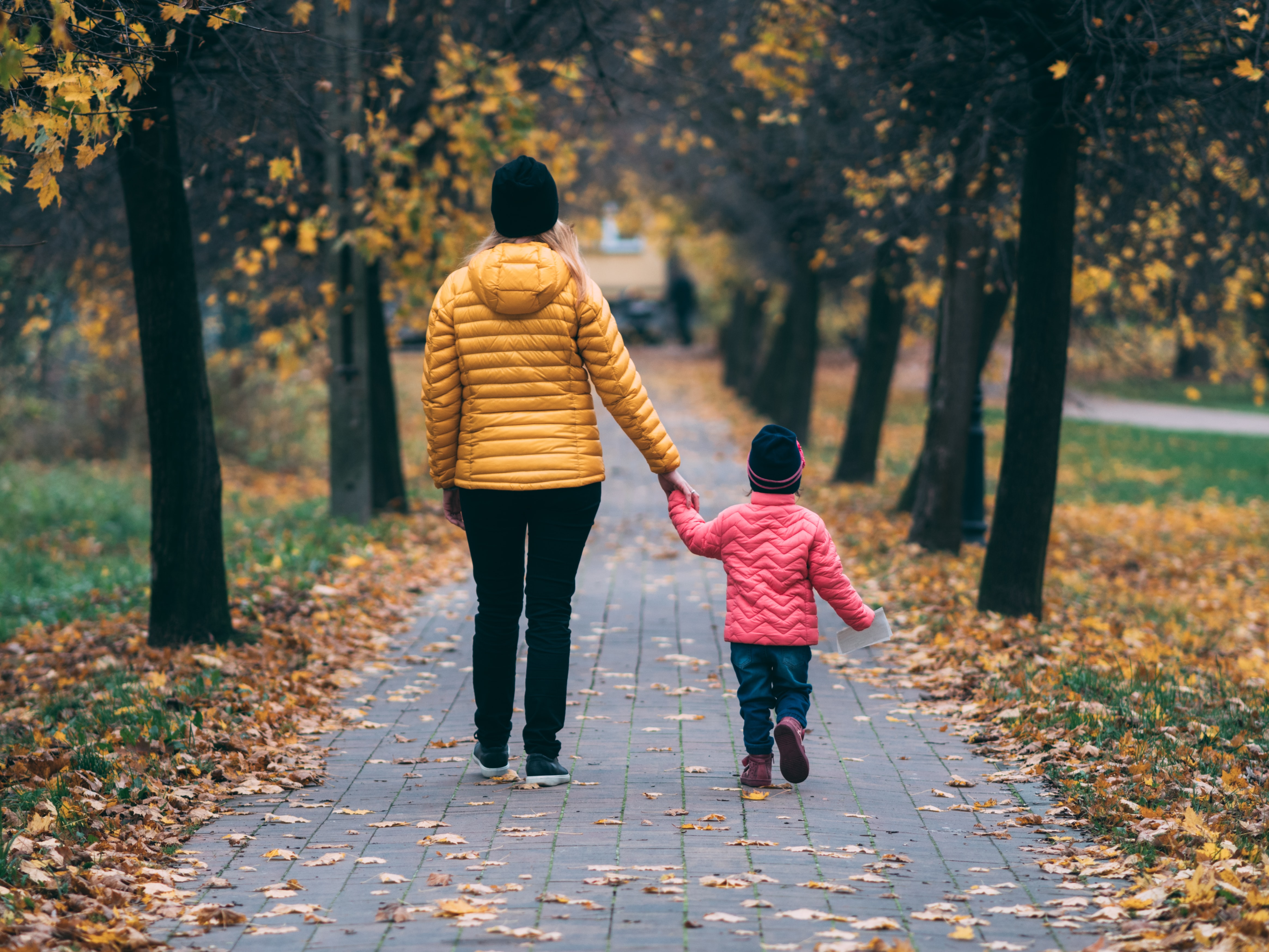Woman holding hands with daughter walking outside | Global agency, BCD Meetings & Events