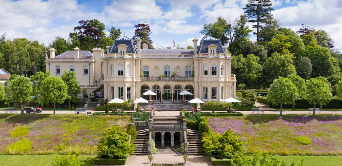 white grand building with stairs down to a lawn