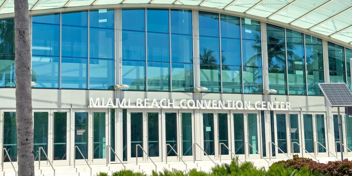 Exterior of the Miami Beach Convention Center with glass facade and main entrance doors.